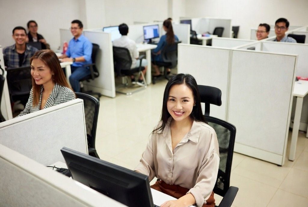 An energetic team of smiling Filipino teammates flashing peace signs in a modern office — the kind of deep, cheerful bench Online VA Team draws from