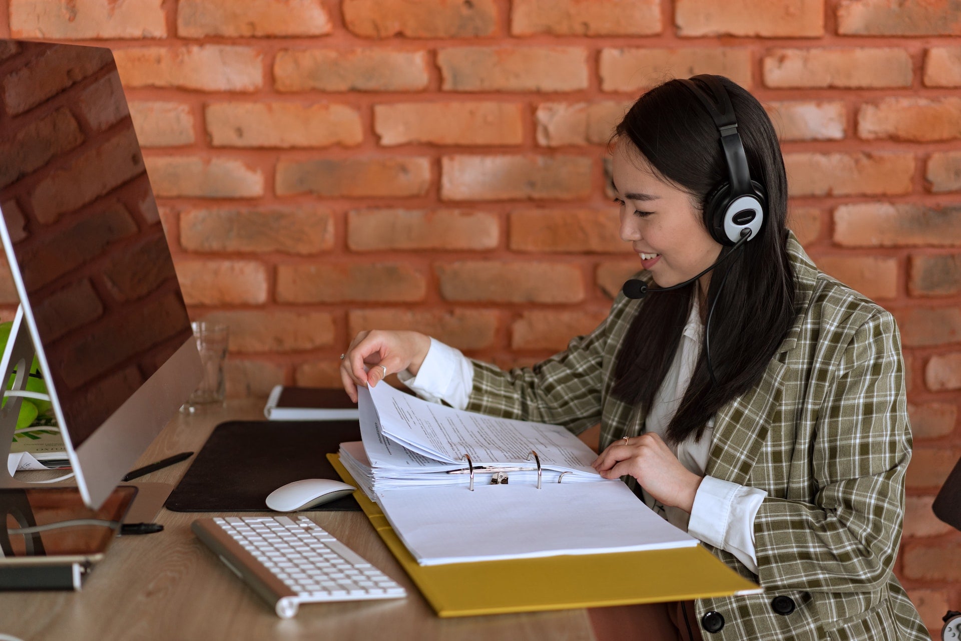 A smiling marketing assistant taking notes from her laptop
