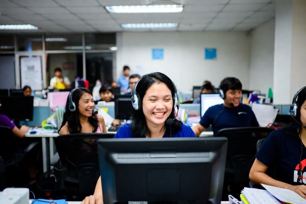 A virtual receptionist on a friendly call, wearing a headset, smiling at the camera
